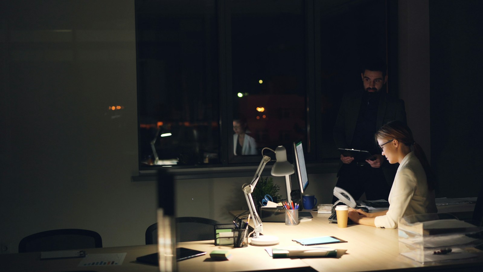 Professional werkt geconcentreerd in een gedimd kantoor